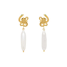 Gold serpent sun shaped earrings with pearl drops on a white background