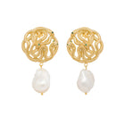 Gold snake earrings with pearl drops on a white background