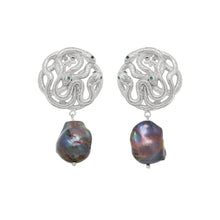 Pair of silver earrings with large black pearls on a white background