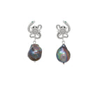 Pair of earrings with serpent design and black pearl on a white background