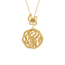 Gold necklace with snake and sun star pendant on a white background