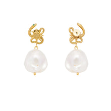 Gold serpent earrings with pearl drops on a white background