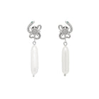 Pair of silver serpent sun design earrings with pearl on a light gray background