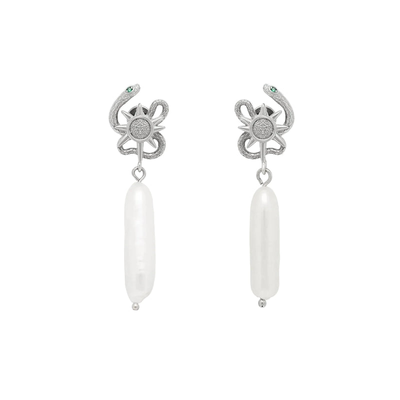 Pair of silver serpent sun design earrings with pearl on a light gray background