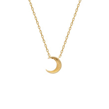 Gold crescent moon necklace on a white background