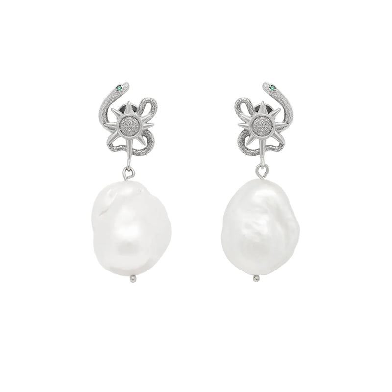 Pair of pearl earrings with silver serpent top on a white background